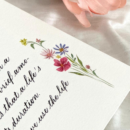 Custom calligraphy letter with watercolor flowers placed in the top corner design