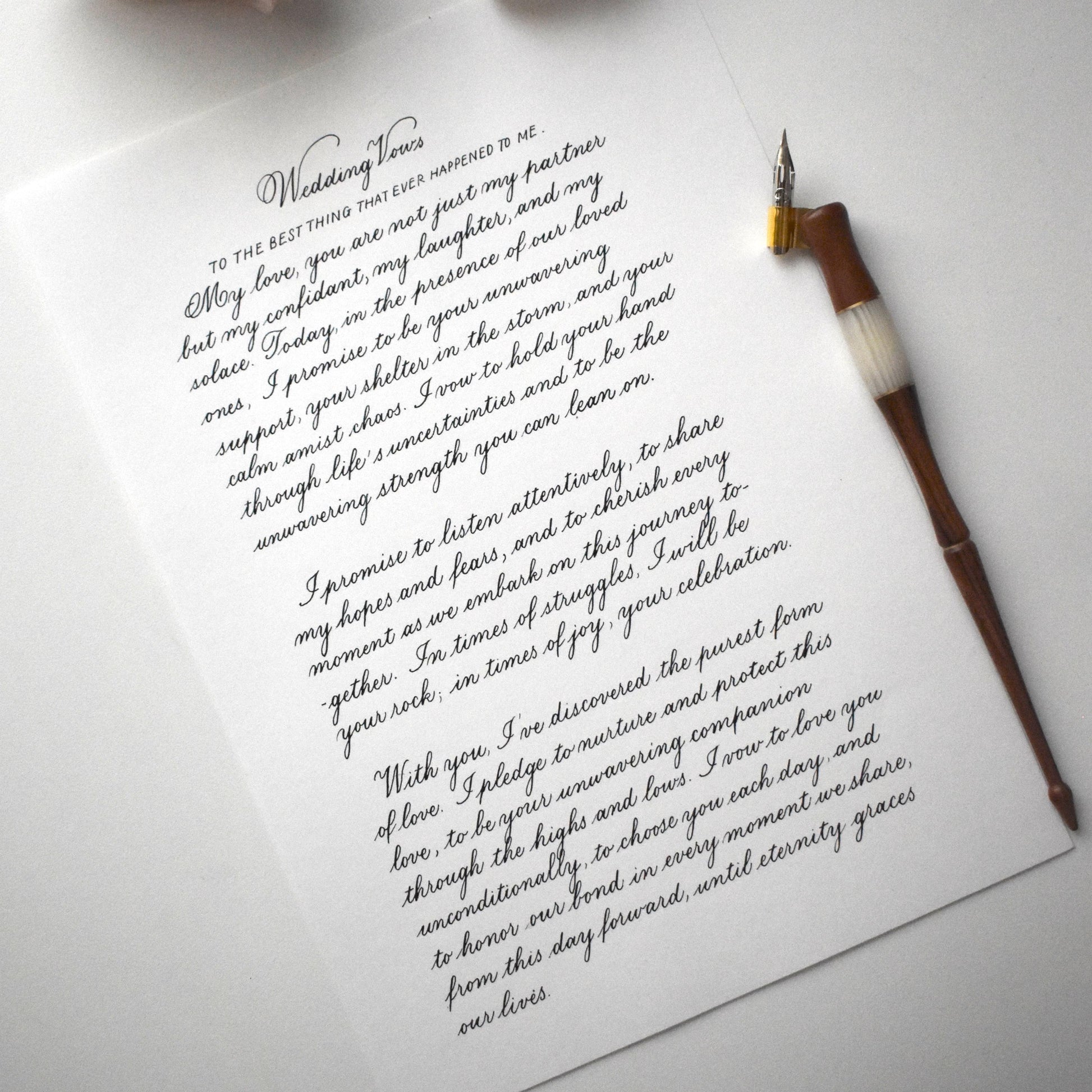Flatlay of copperplate calligraphy letter with dip pen on A4 paper elegant handwritten script herpens