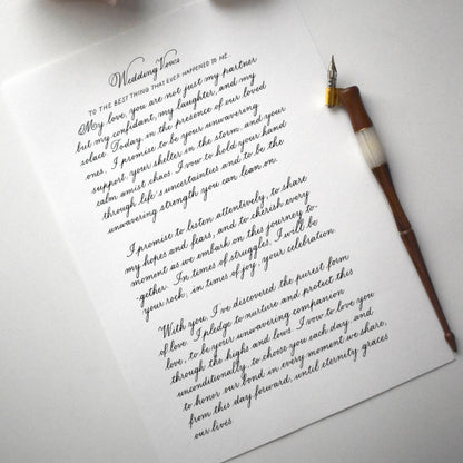 Flatlay of copperplate calligraphy letter with dip pen on A4 paper elegant handwritten script herpens