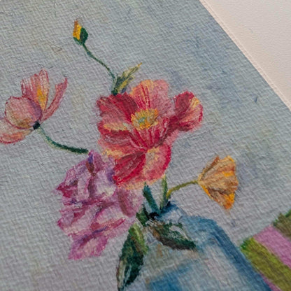 Close-up of a floral painting with pink, red, and yellow flowers on textured paper.