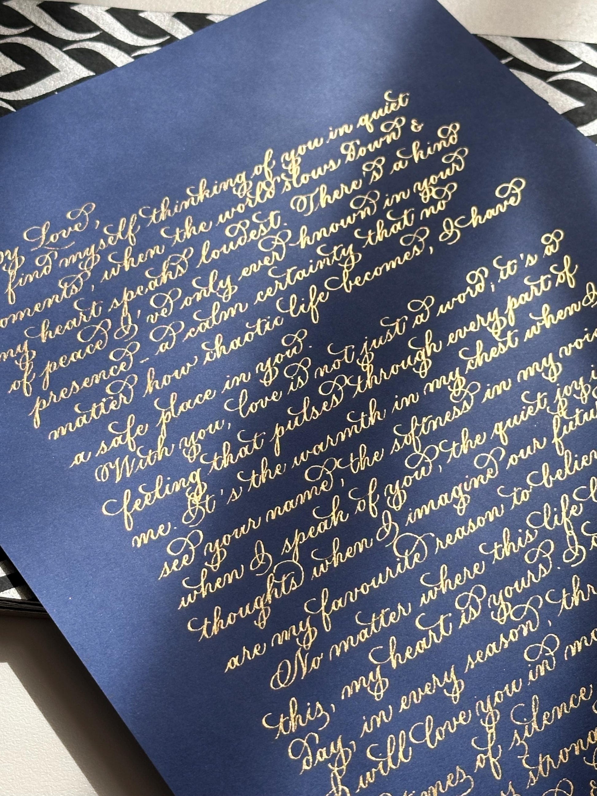Handwritten flourishing calligraphy letter in metallic gold ink on navy blue paper elegant wedding vows keepsake herpens