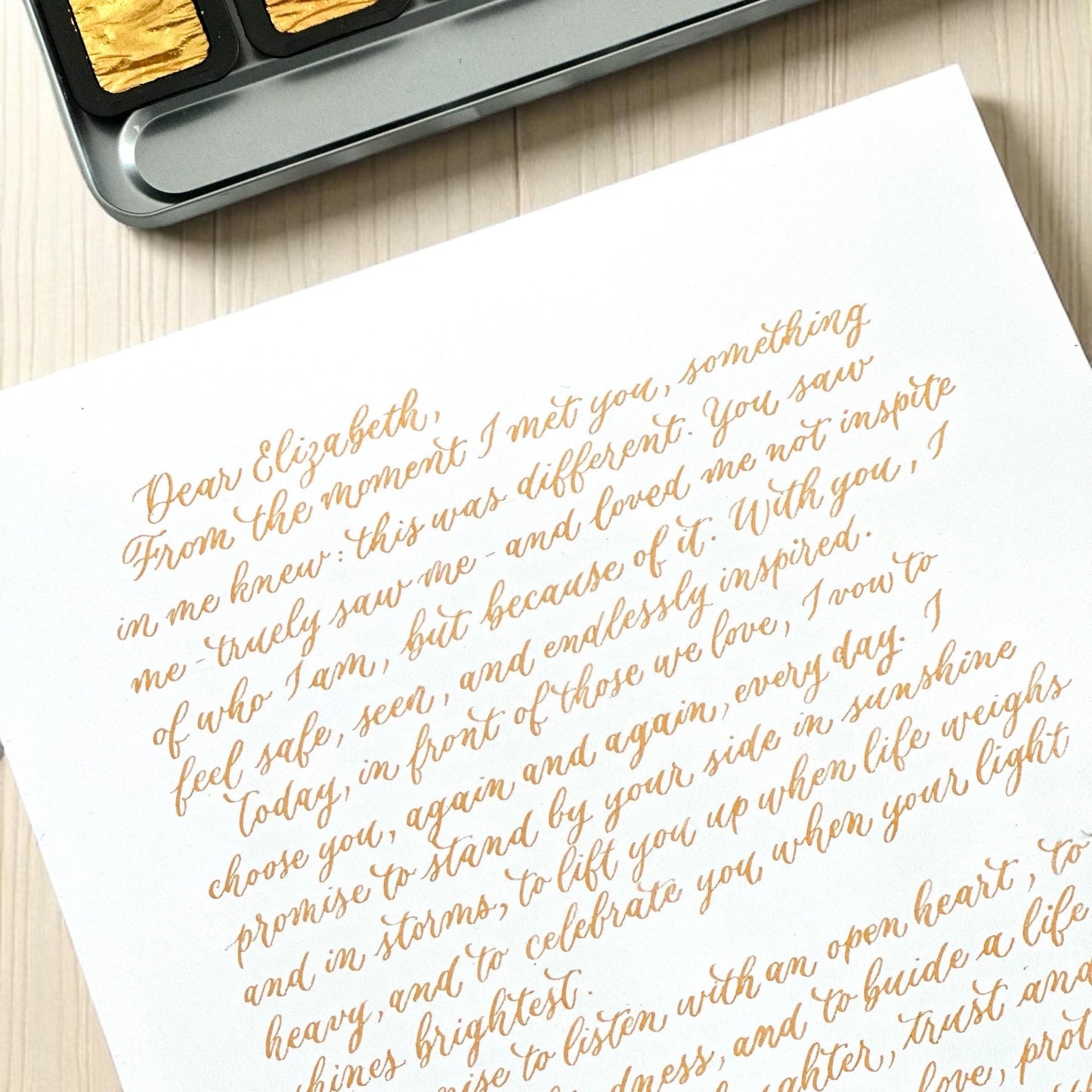 Handwritten gold ink calligraphy letter on white A4 paper elegant modern script wedding vows keepsake herpens