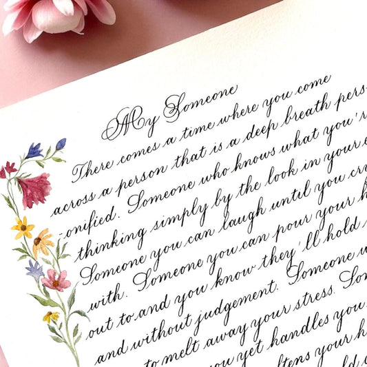 Close up of handwritten calligraphy letter with delicate watercolor flowers and elegant cursive script