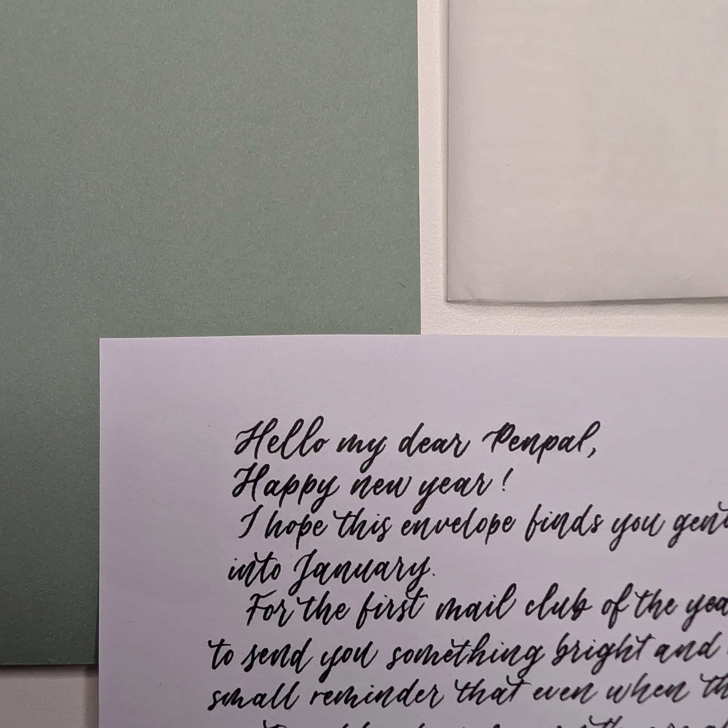 Letter on a card with a penultimate envelope, set against a green and beige background.