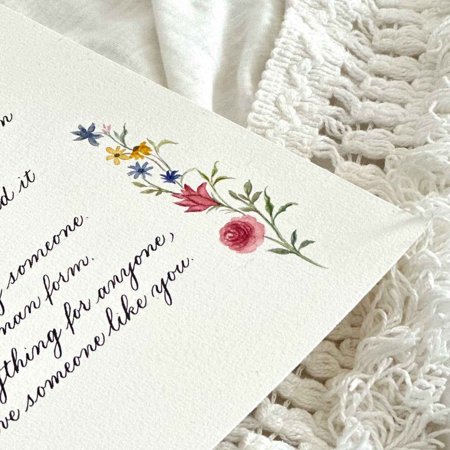 Minimal handwritten calligraphy letter with subtle watercolor floral accents on white paper