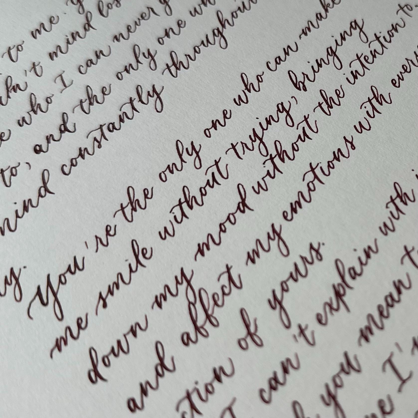 Close up of modern calligraphy script in brown ink showing elegant flowing handwritten lettering herpens