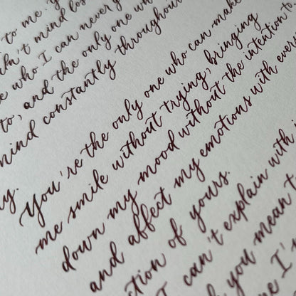 Close up of modern calligraphy script in brown ink showing elegant flowing handwritten lettering herpens