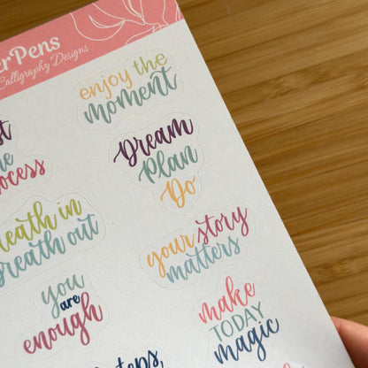 Handwritten detailed view of modern calligraphy quote stickers in pastel tones printed on matte paper herpens