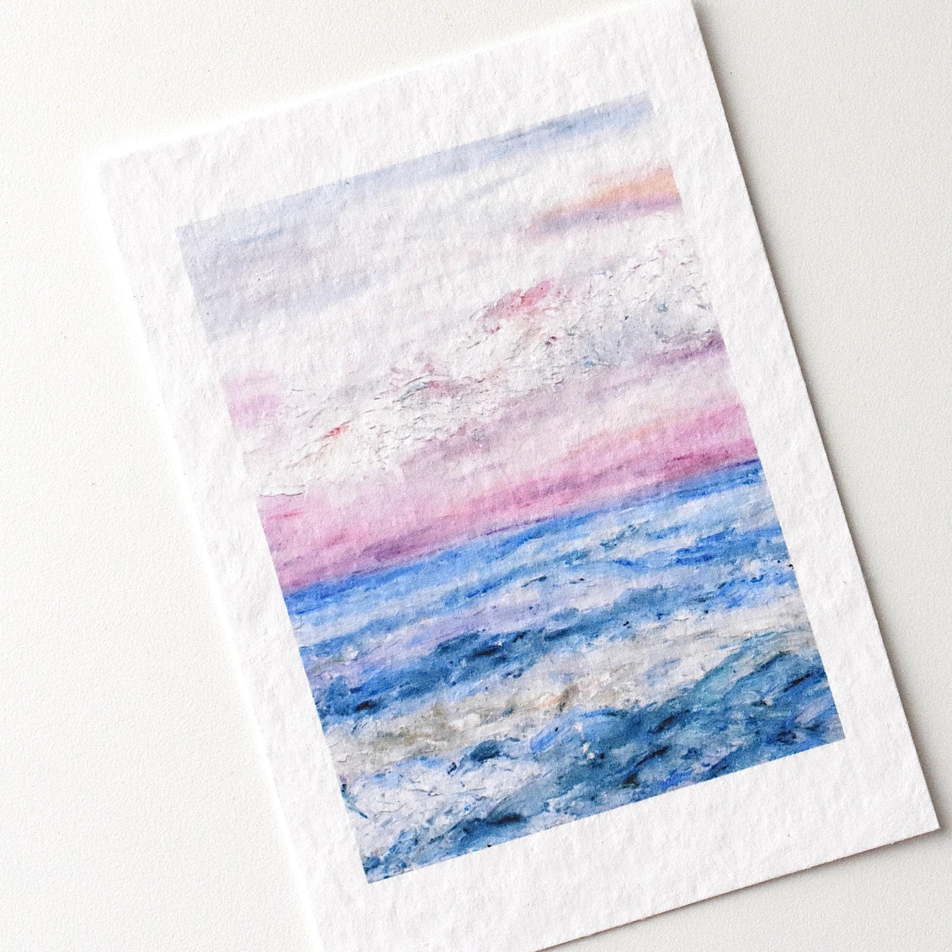 A6 oil pastel postcard of gentle ocean waves under a pink and blue sunset horizon — calming seascape print by HerPens.