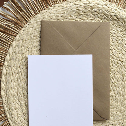Kraft paper envelope and card on a woven mat
