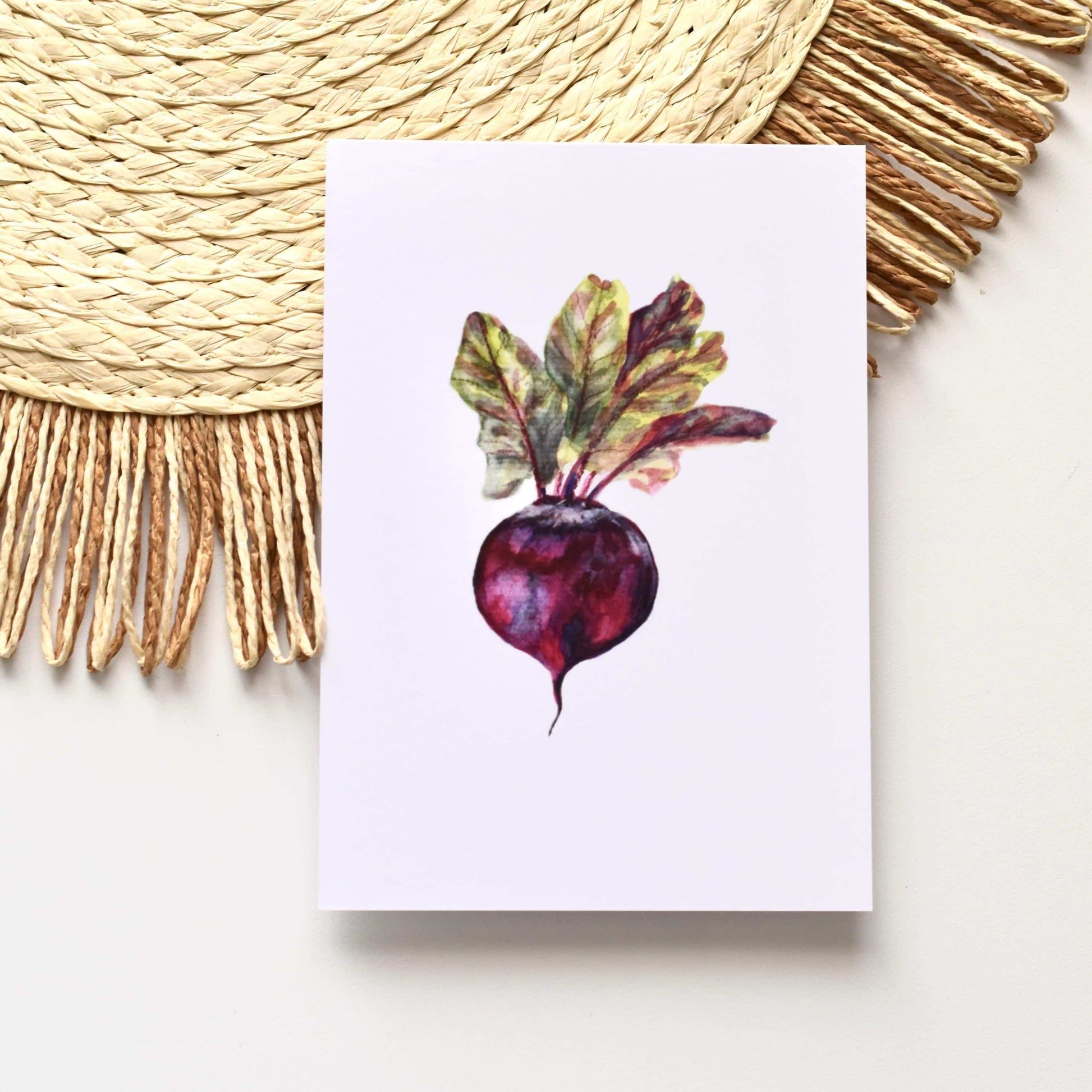 Note card with a watercolor illustration of a beetroot on a white surface with a woven mat.