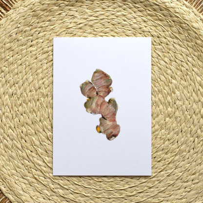 Turmeric root on a white card with a woven mat background