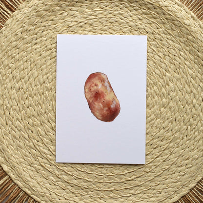 Postcard with a potato on a woven mat