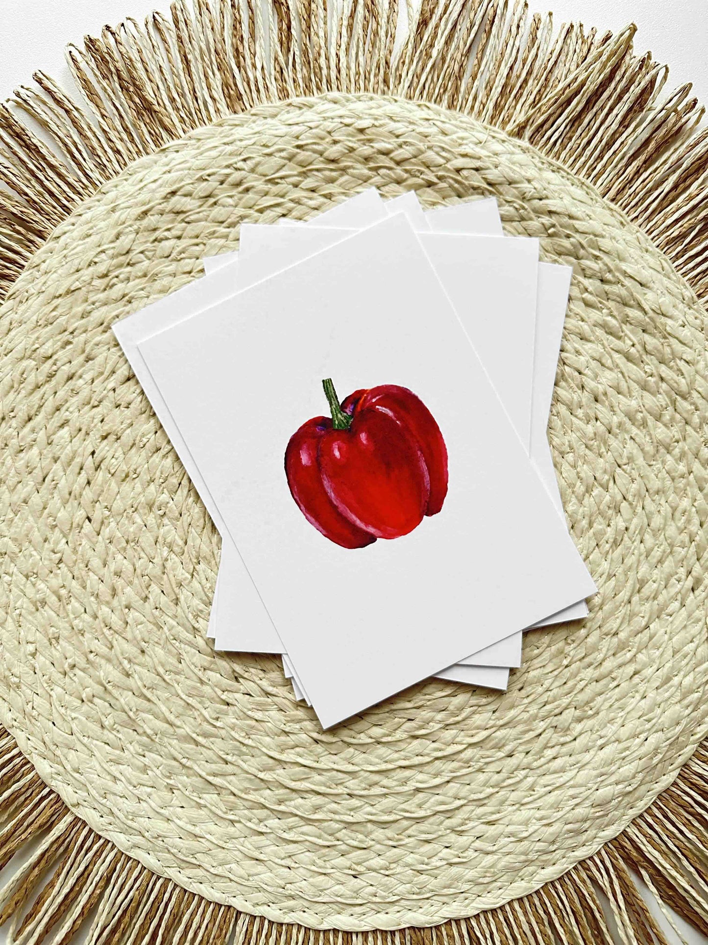 Stack of cards with a red apple illustration on a woven placemat