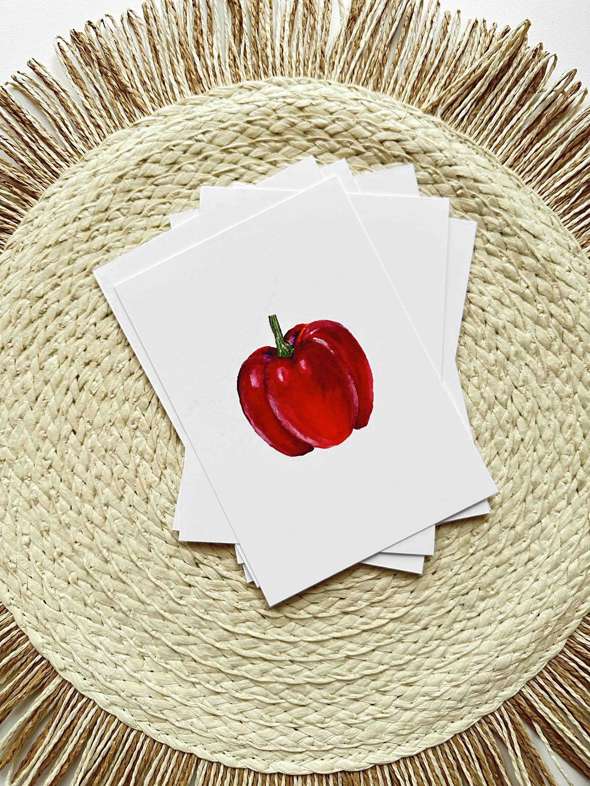 Stack of cards with a red apple illustration on a woven placemat