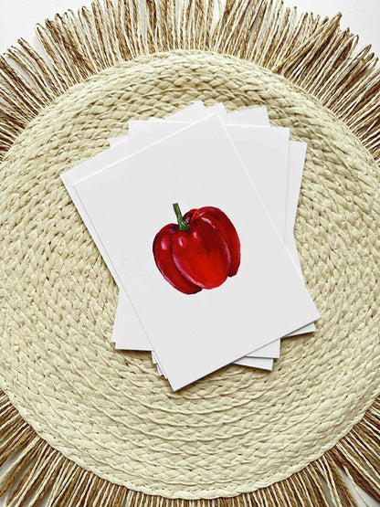 Stack of cards with a red apple illustration on a woven placemat