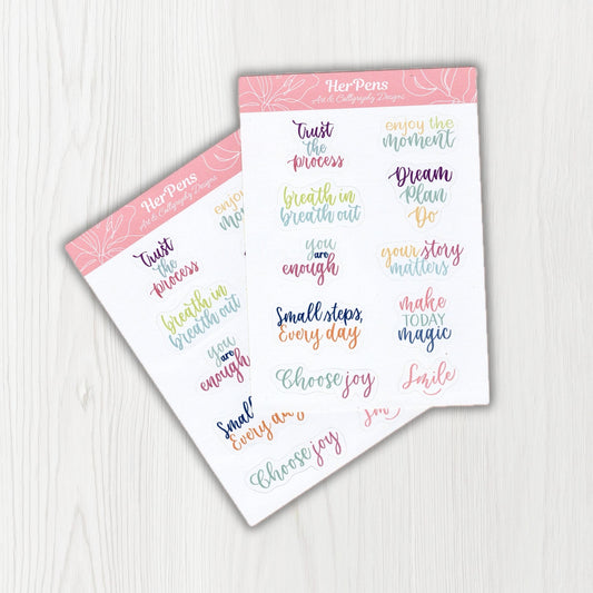 Handwritten close up of pastel modern calligraphy quote stickers with soft colors on matte sticker paper herpens
