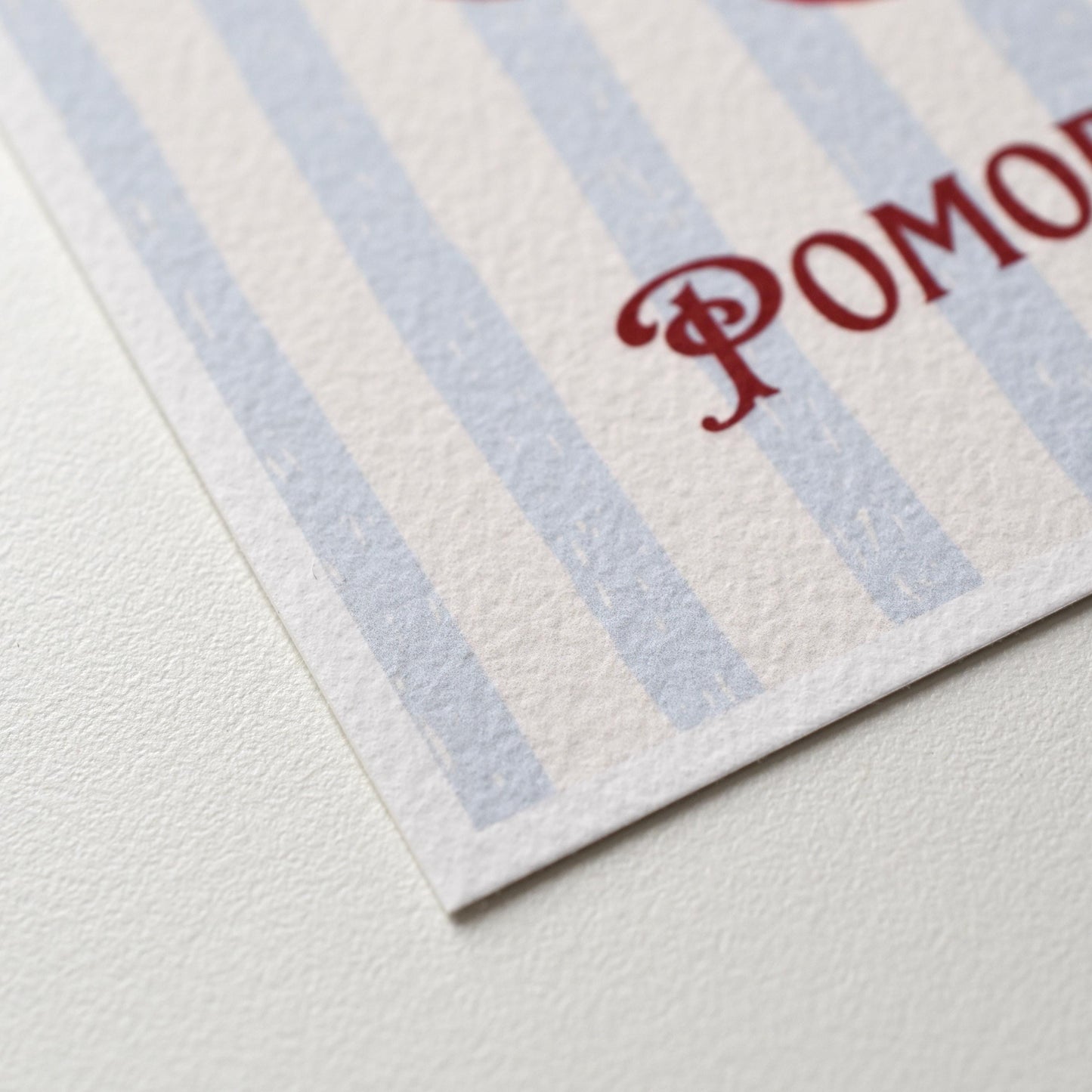 Close-up of the “Pomodoro” A6 postcard — showing the fine art paper’s textured surface and soft oil pastel details of the tomato illustration by HerPens.