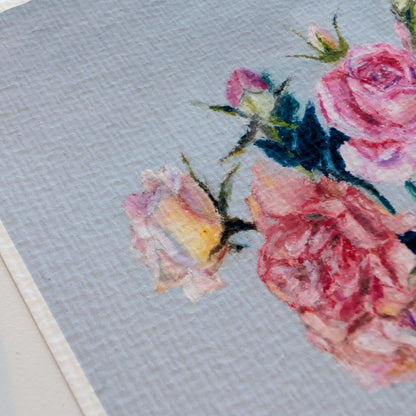Floral cross-stitch pattern on fabric with a light blue background