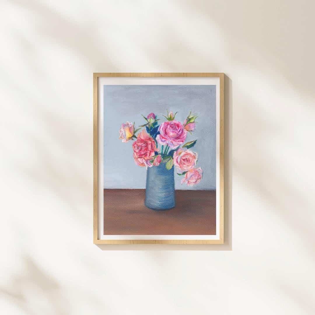 Framed artwork of a vase with pink flowers on a neutral wall