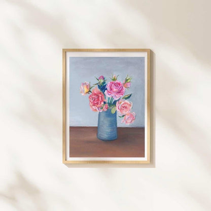 Framed artwork of a vase with pink flowers on a neutral wall