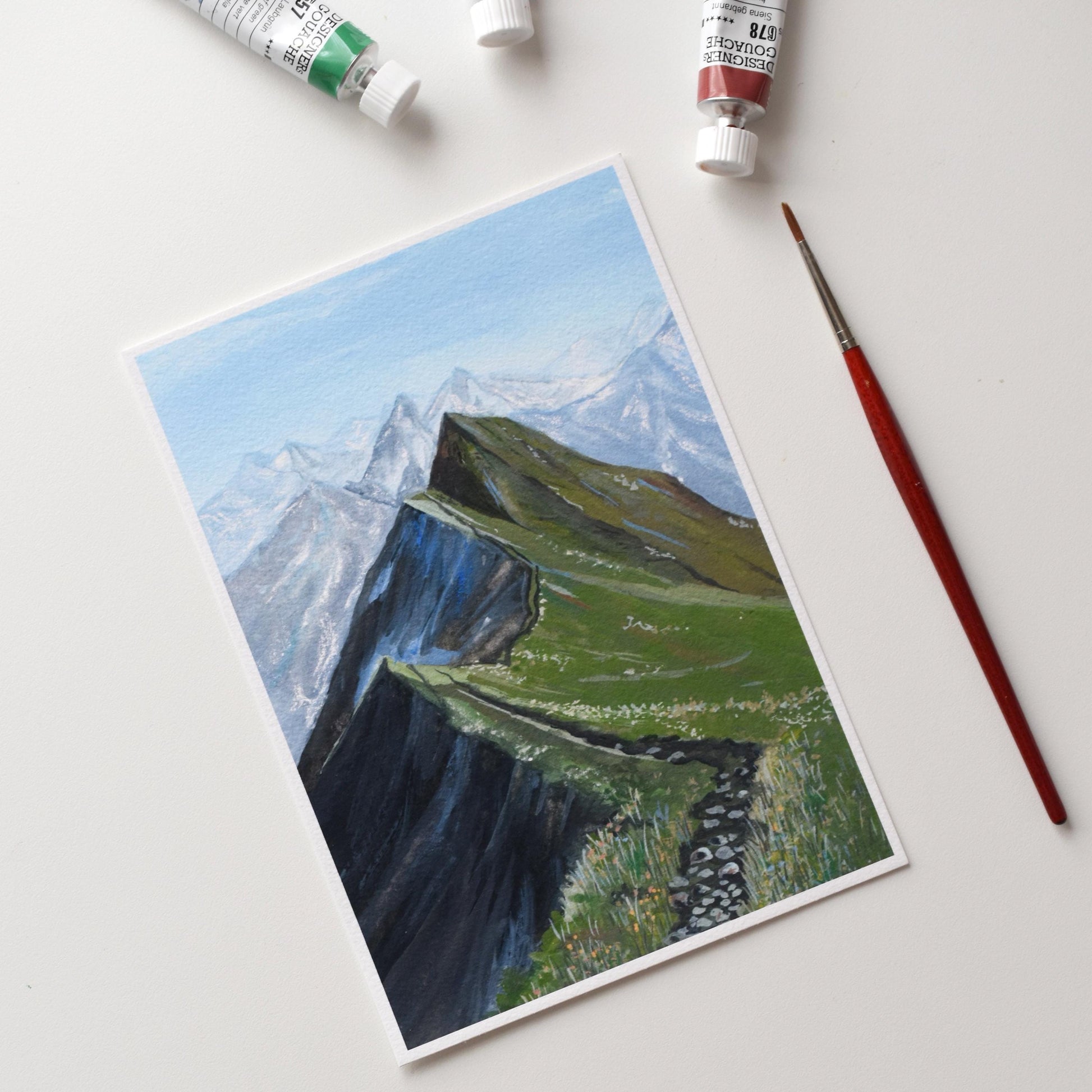 Full view of the “Verdant Peaks” art print on white background — green mountain ridge path leading into misty peaks, printed on textured fine art paper.