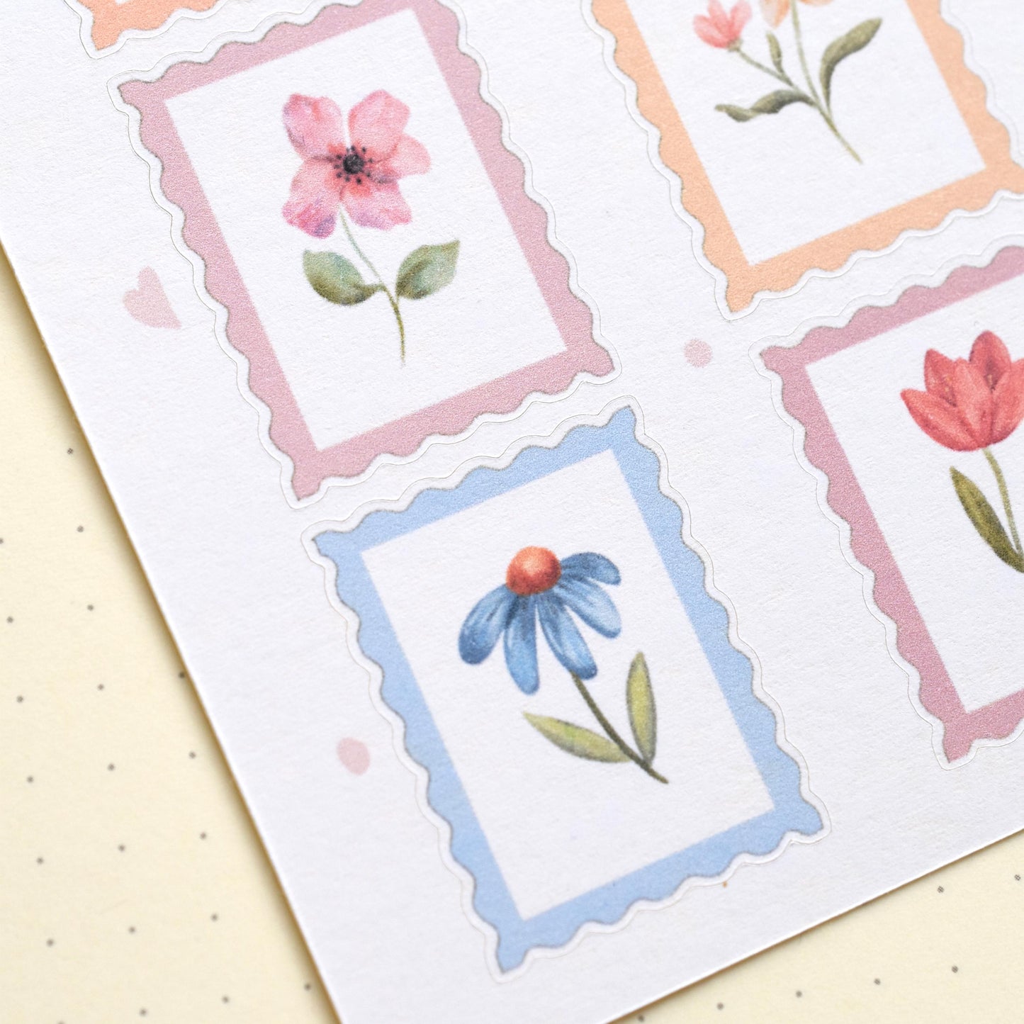 Detail of watercolor flower stamp stickers with visible cut lines on matte sticker sheet herpens