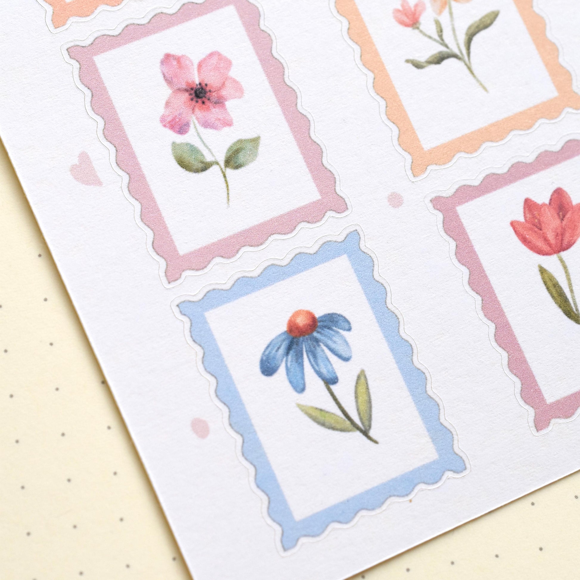 Detail of watercolor flower stamp stickers with visible cut lines on matte sticker sheet herpens