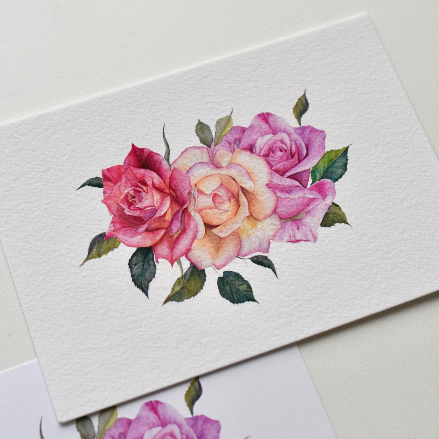 Watercolor roses postcard on textured fine art paper, painterly rose strokes and tactile paper surface visible, HerPens